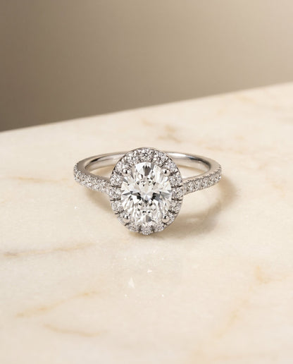 Sade Select Classic French Pavé Halo Linear Oval Lab Diamond Engagement Ring in Platinum, shown on hand, angled | RockHer