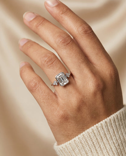 Selena Select Clover Bezel Accent Solitaire Radiant Cut Lab Diamond Engagement Ring in 18K White Gold, shown on hand | RockHer