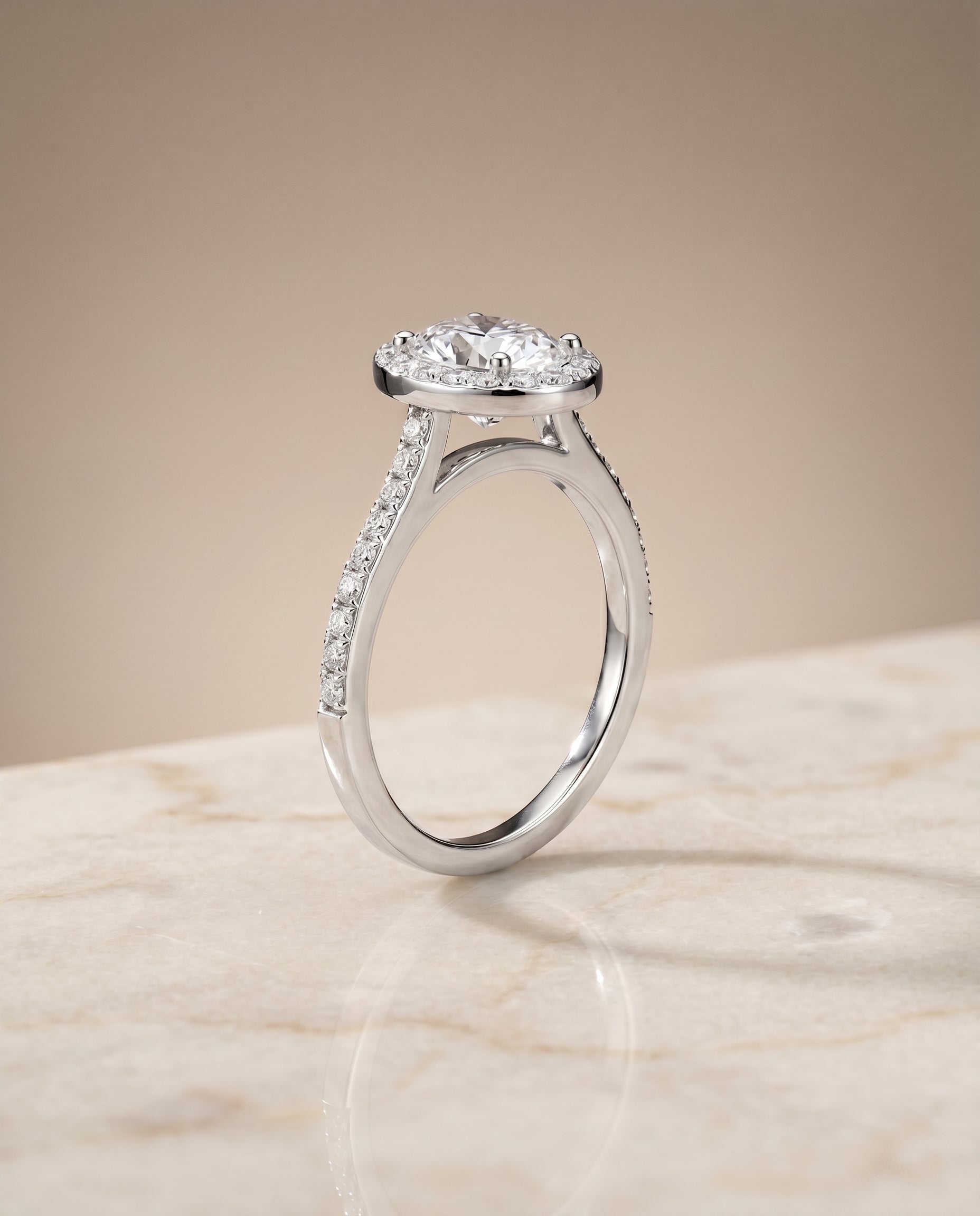 Taylor Select Pavé Halo Oval Lab Diamond Engagement Ring in Platinum, shown on hand, angled | RockHer
