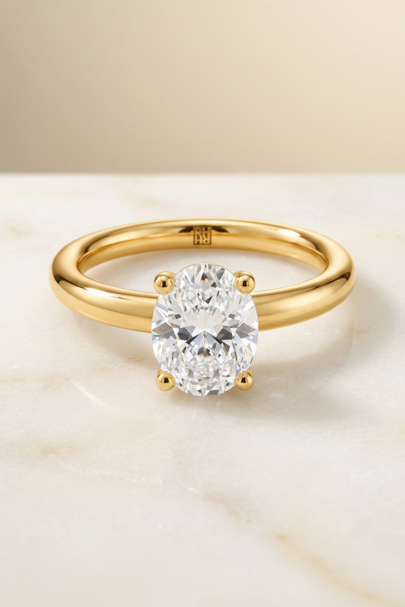 The Tori Select Rounded Comfort Fit Solitaire Oval Lab Diamond Engagement Ring in 18K Yellow Gold, shown on hand, angled | RockHer