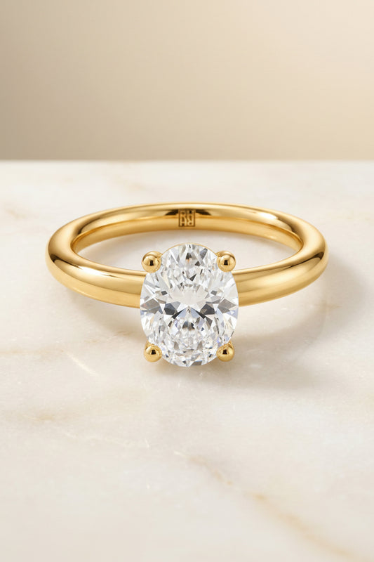 The Tori Select Rounded Comfort Fit Solitaire Oval Lab Diamond Engagement Ring in 18K Yellow Gold, shown on hand, angled | RockHer