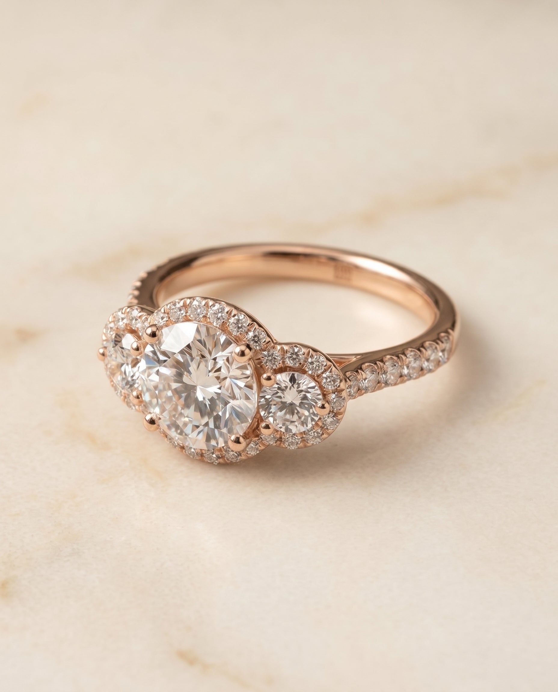 Round Brilliant, Three Stone Halo, in 14K Rose Gold, pave setting – angled view | RockHer