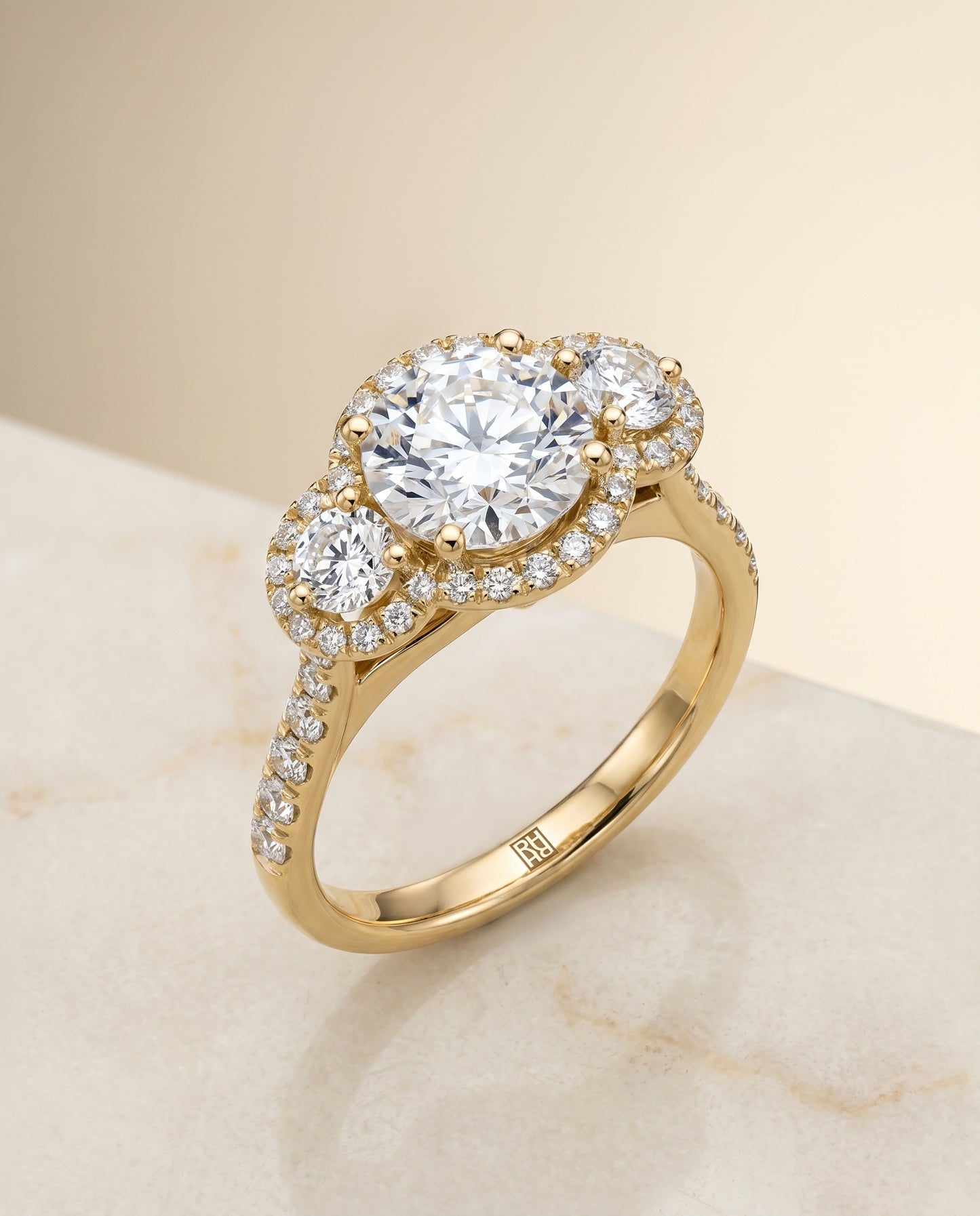 Round Brilliant, Three Stone Halo, in 18K Yellow Gold, pave setting – angled view | RockHer