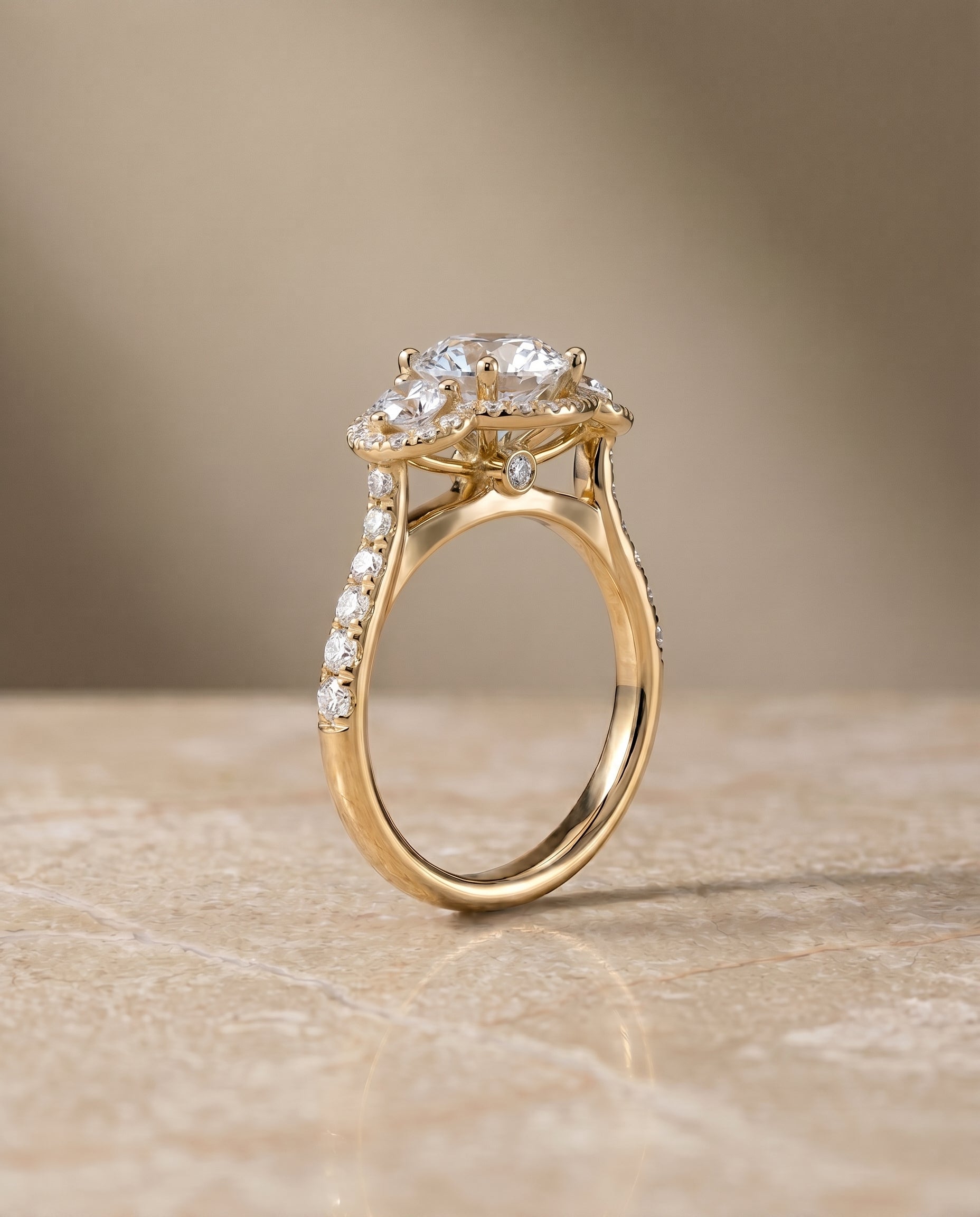 The Andrea three stone halo engagement ring setting, shown in 18K Yellow Gold | RockHer
