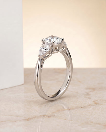 Angelica Select Three Stone Matched Cushion Cut Lab Diamond Engagement Ring in Platinum, shown on hand, angled | RockHer