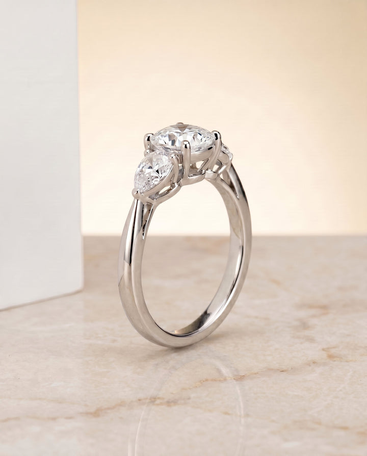 Angelica Select Three Stone Matched Cushion Cut Lab Diamond Engagement Ring in Platinum, shown on hand, angled | RockHer