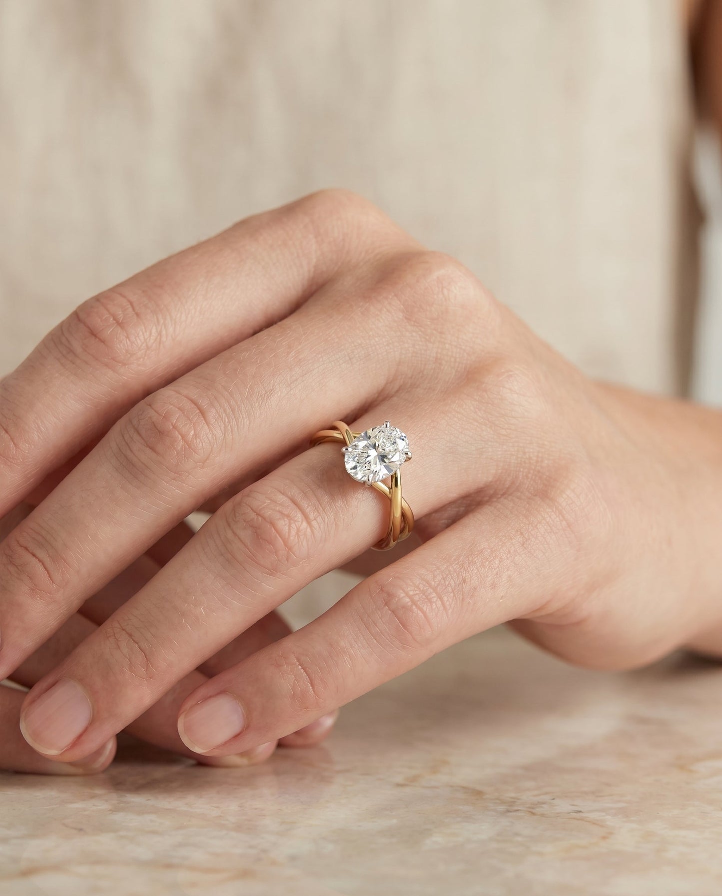 Grace Select Twisted Shank Hidden Halo Solitaire Oval Lab Diamond Engagement Ring in 18K Yellow Gold, shown on hand, angled | RockHer