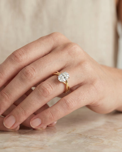 Grace Select Twisted Shank Hidden Halo Solitaire Oval Lab Diamond Engagement Ring in 18K Yellow Gold, shown on hand, angled | RockHer
